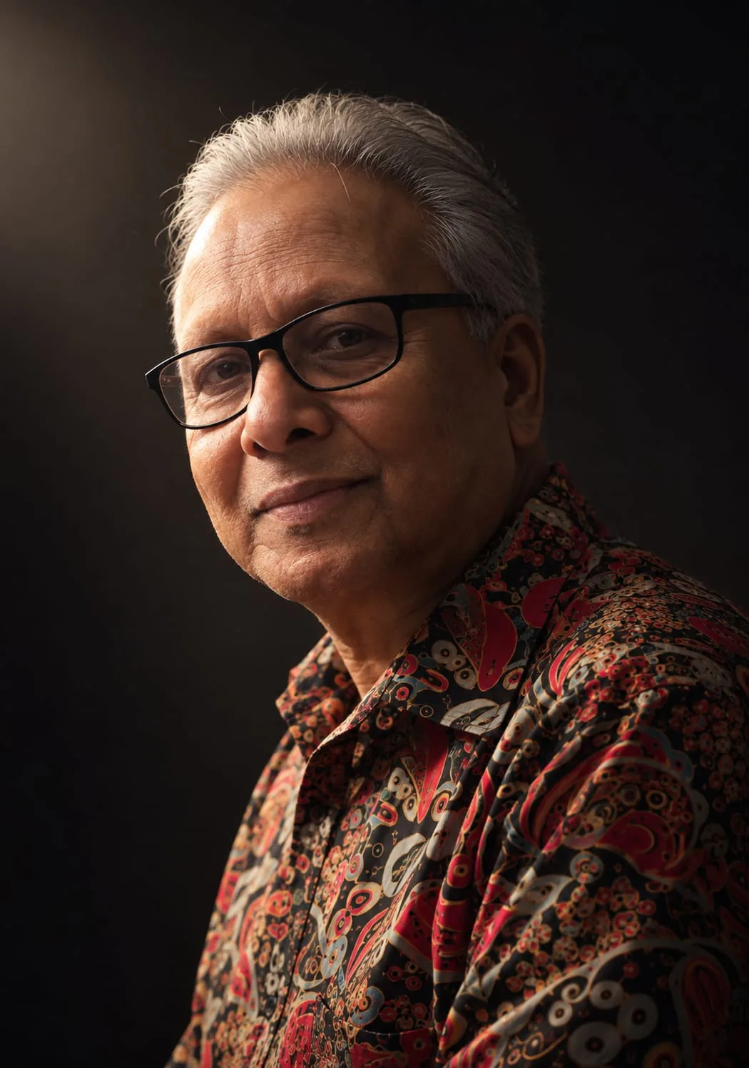 Portrait of Anand Channar wearing black glasses and a patterned shirt